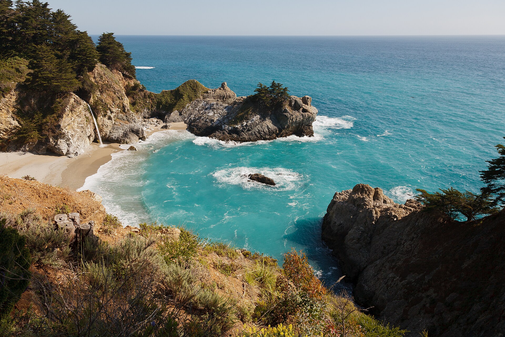 McWay Falls dropping onto the sand of a small cove framed by cliffs at Julia Pfeiffer Burns State Park