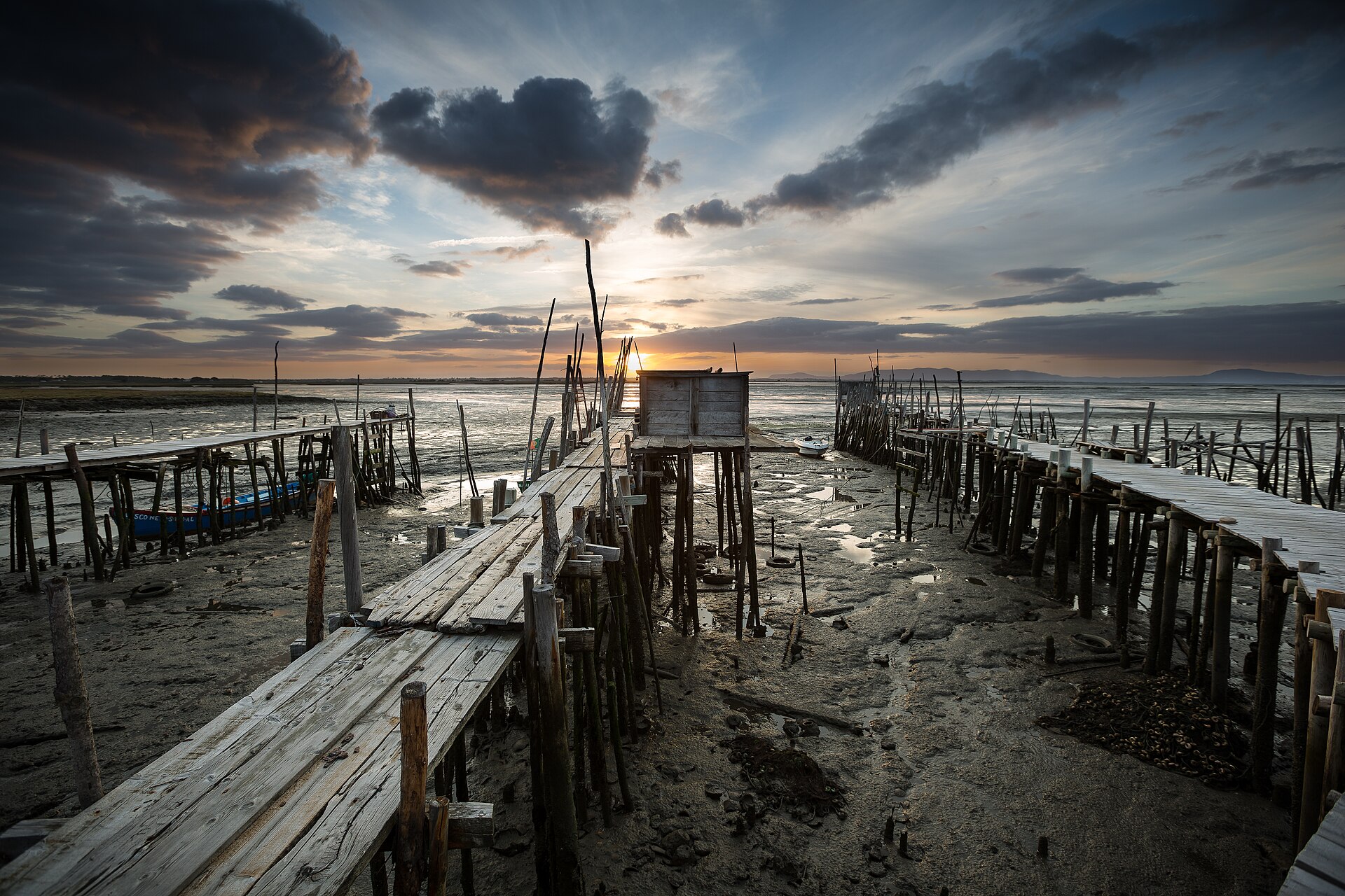 The weathered wooden stilt pier at Carrasqueira reaching over the mudflats of the Sado estuary