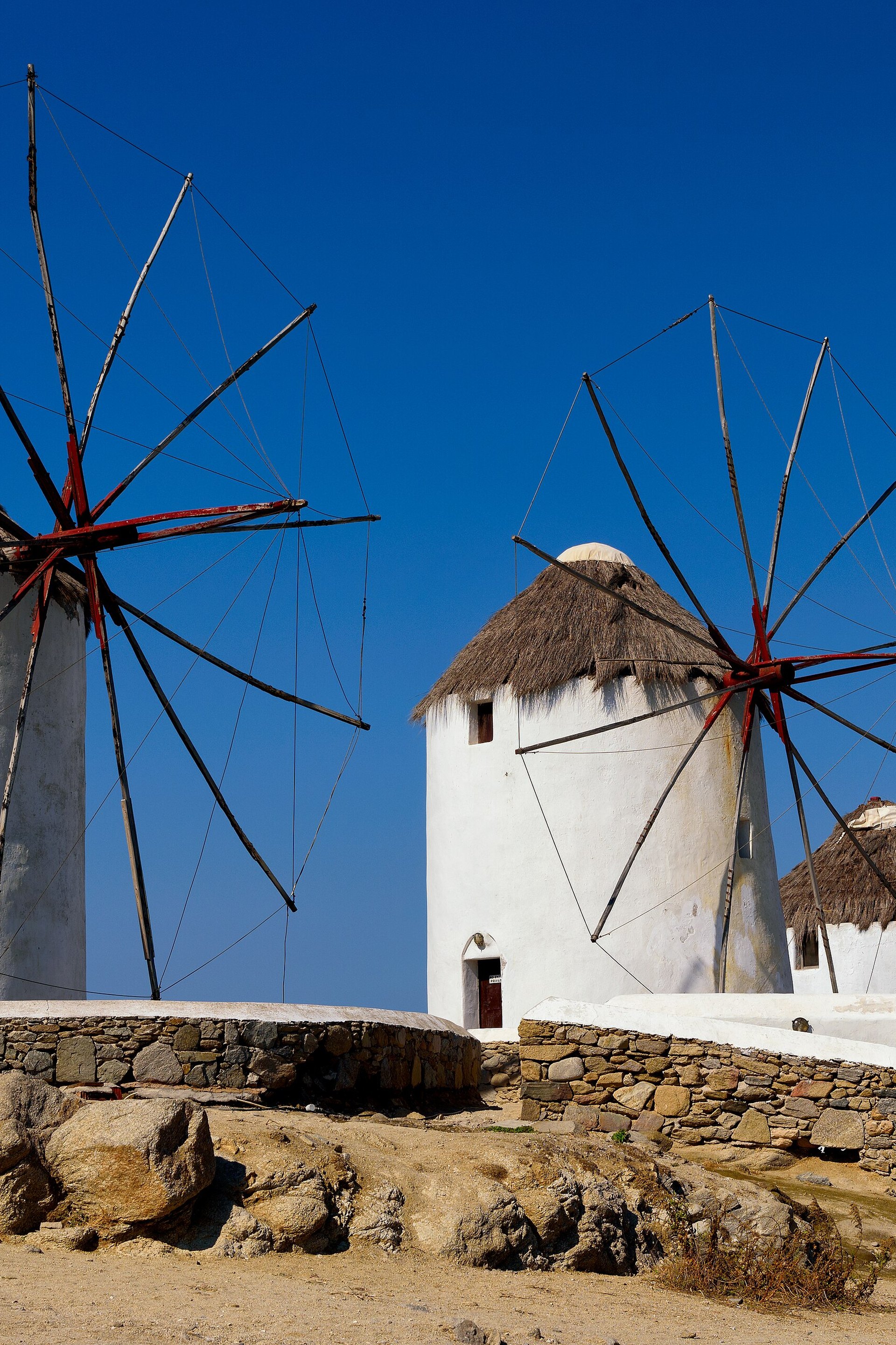 A row of whitewashed windmills, the Kato Mili, on the rise above Mykonos Town at dusk
