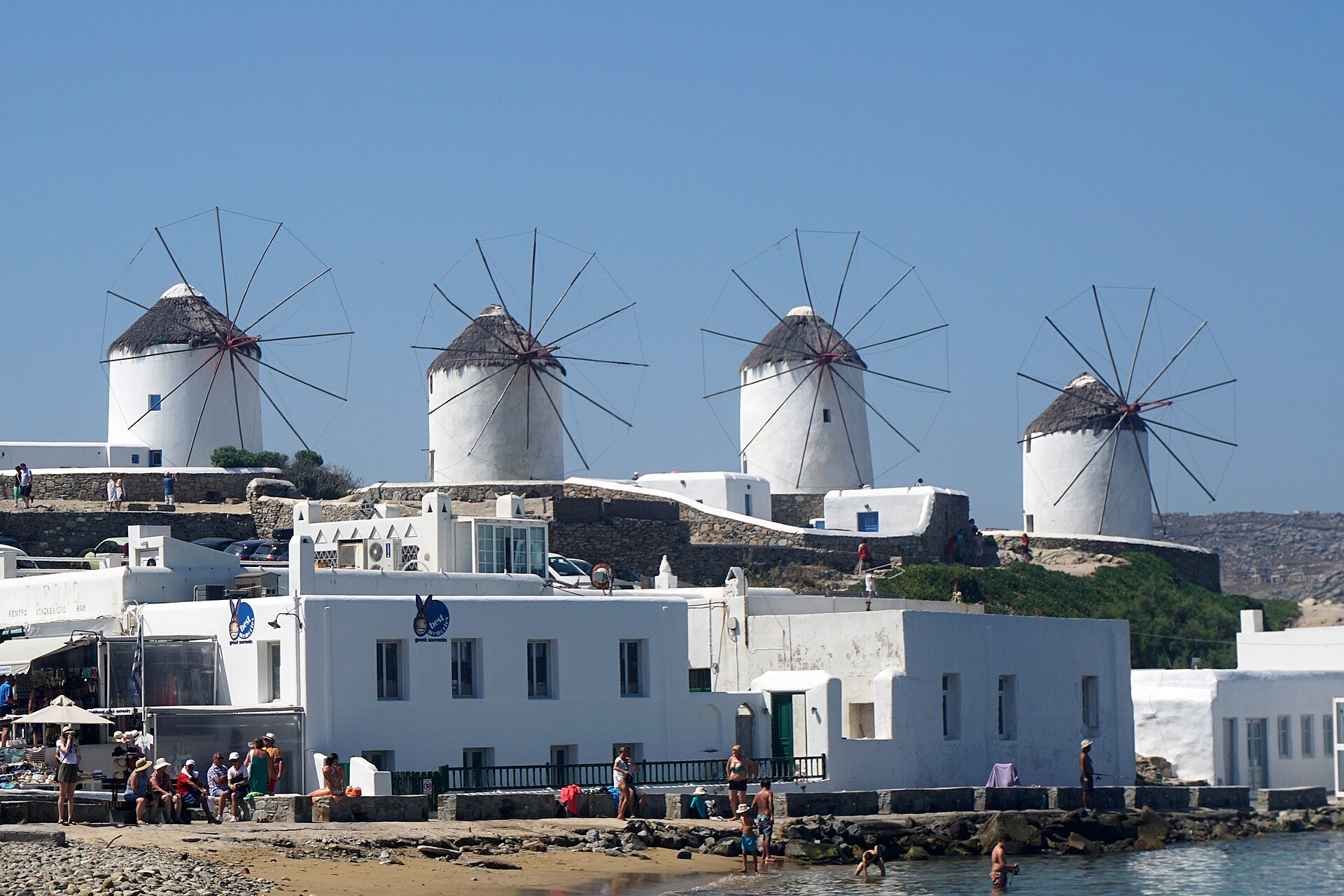 A row of whitewashed windmills, the Kato Mili, on the rise above Mykonos Town at dusk