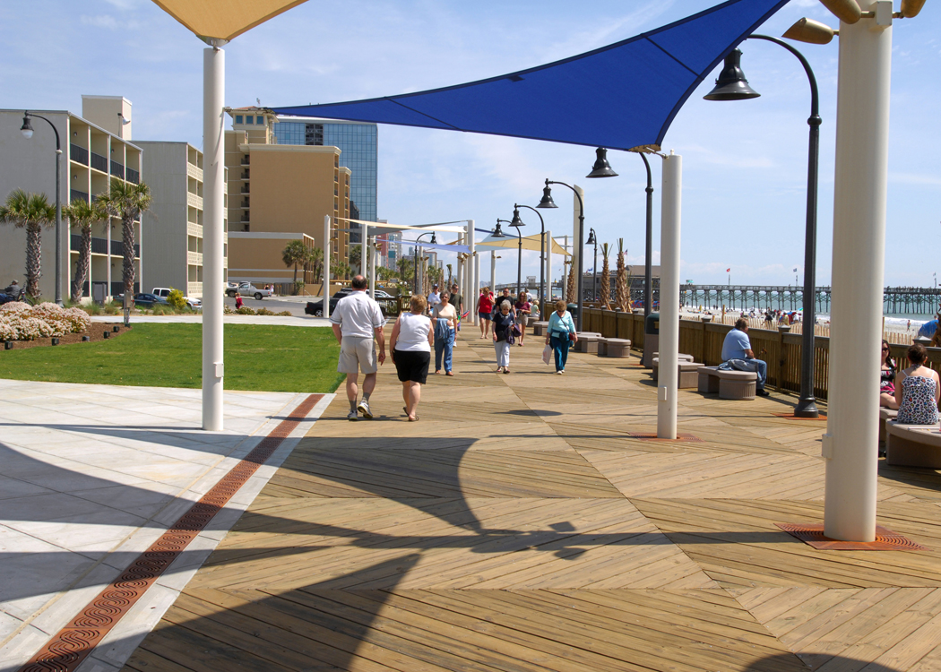 The Oceanfront Boardwalk and Promenade in Myrtle Beach, South Carolina, with the SkyWheel observation wheel rising above shops and the wide sandy beach.