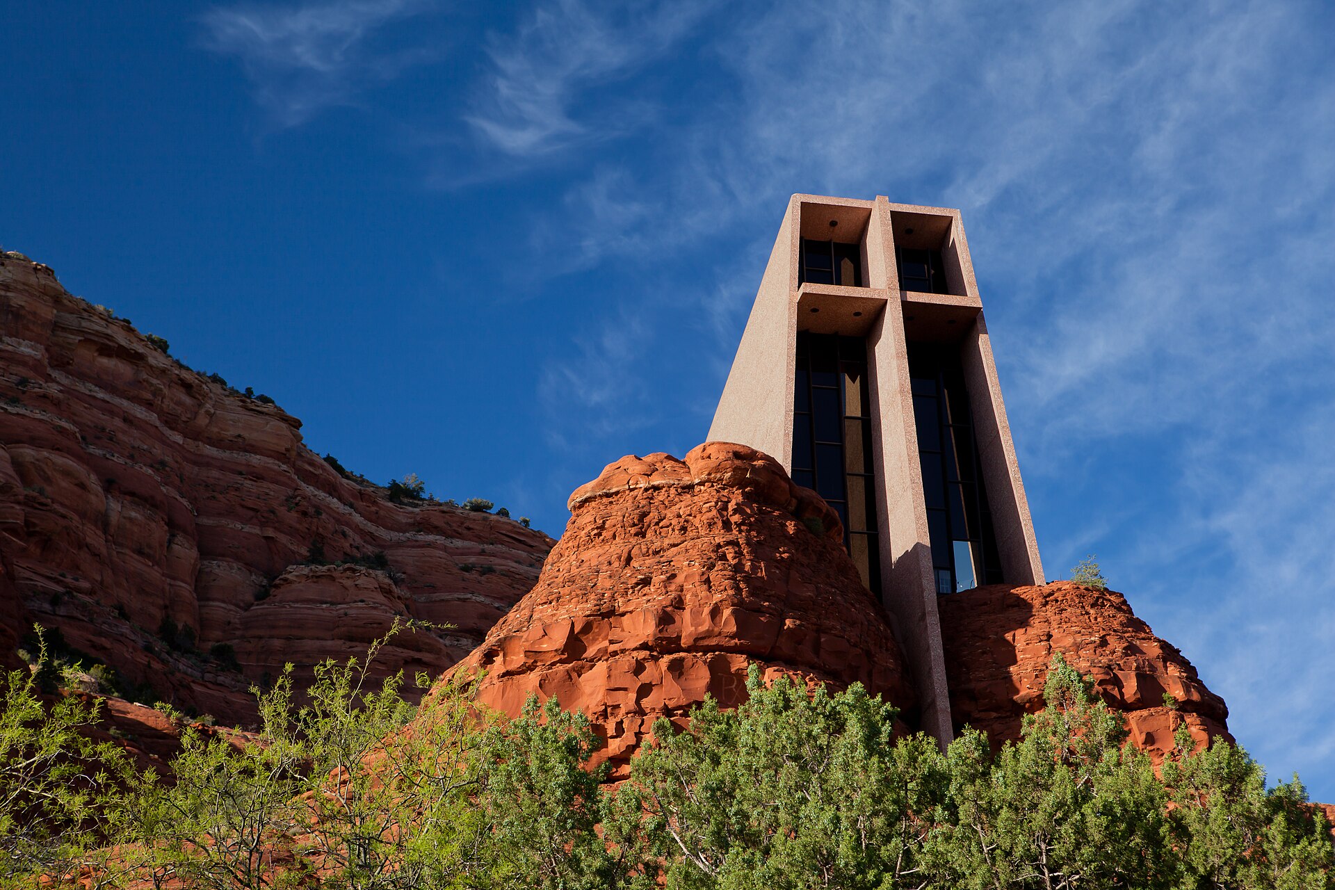 The Chapel of the Holy Cross set into the red rock outside Sedona, its concrete face and tall cross rising between sandstone walls.