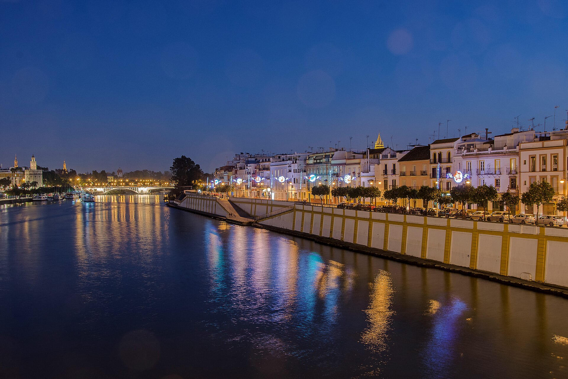 The riverside terraces of Calle Betis in the Triana district, looking across the Guadalquivir to the old city of Seville.