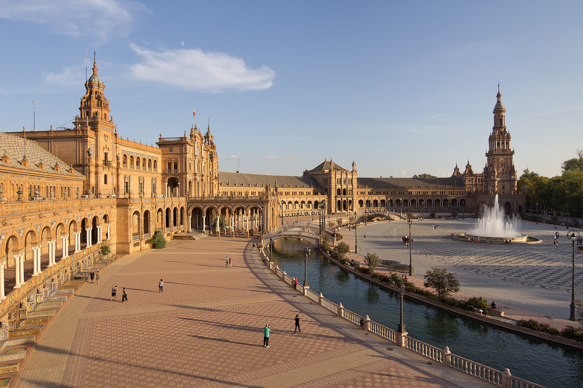 The semicircular brick-and-tile façade of the Plaza de España in Seville, with its bridges over a curved canal.