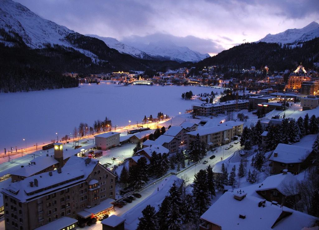 St. Moritz and its frozen lake below the town, ringed by the snow-covered mountains of the Engadin in winter.