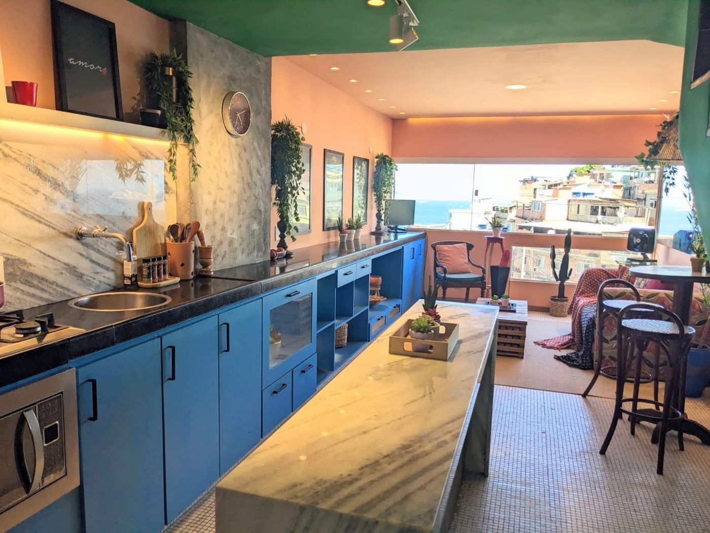 Cobalt-blue kitchen with marble counter opening onto the living area at Lux Vidigal