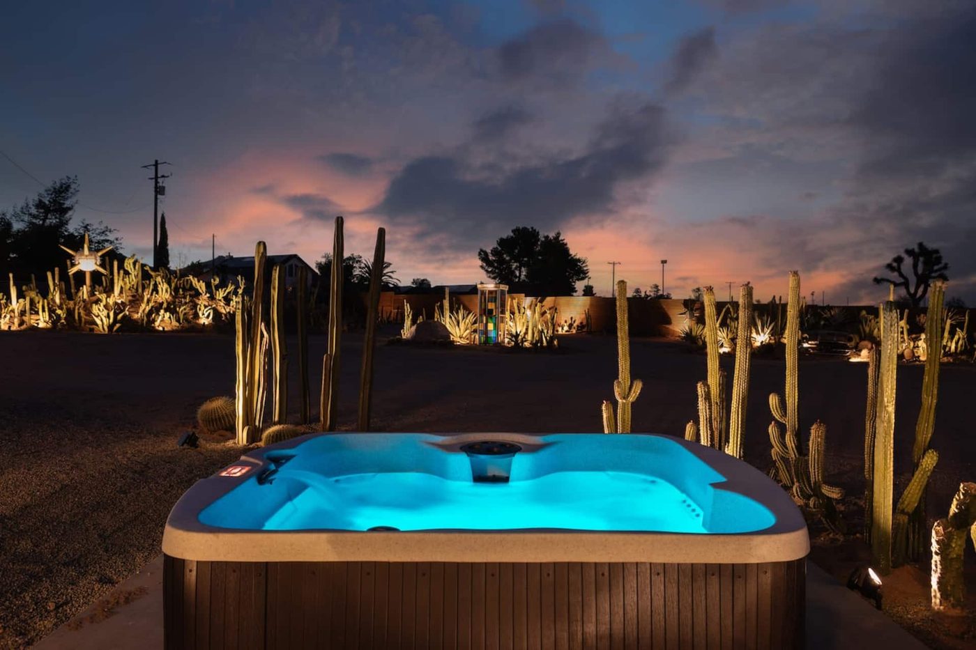 The private hot tub at Stargaze Escape glowing turquoise at dusk, surrounded by cacti under open sky