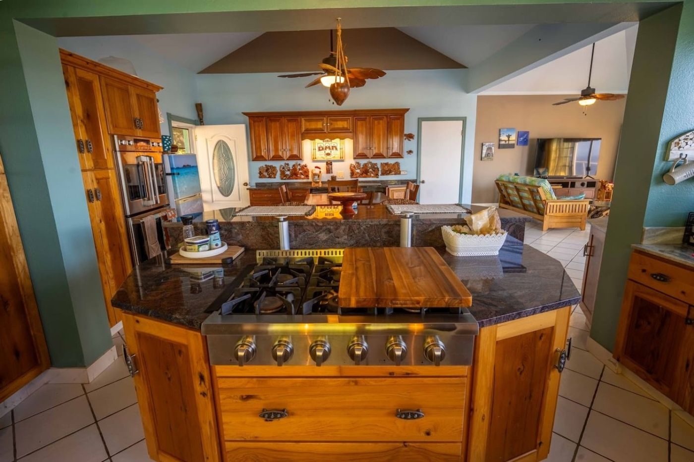 Wood kitchen with an island holding a gas cooktop and a butcher-block counter