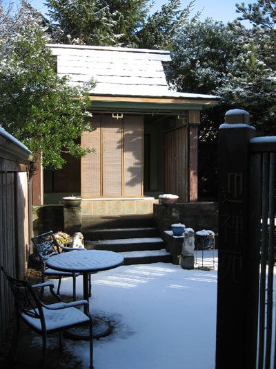 The outdoor Zen Bath house in the garden, snow on its roof
